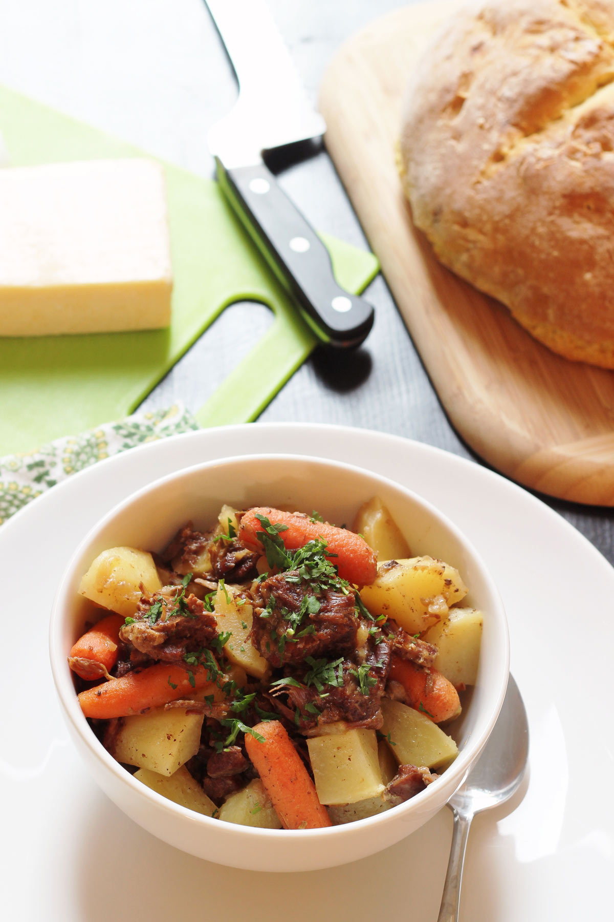 bowl of stew on table with bread and cheese