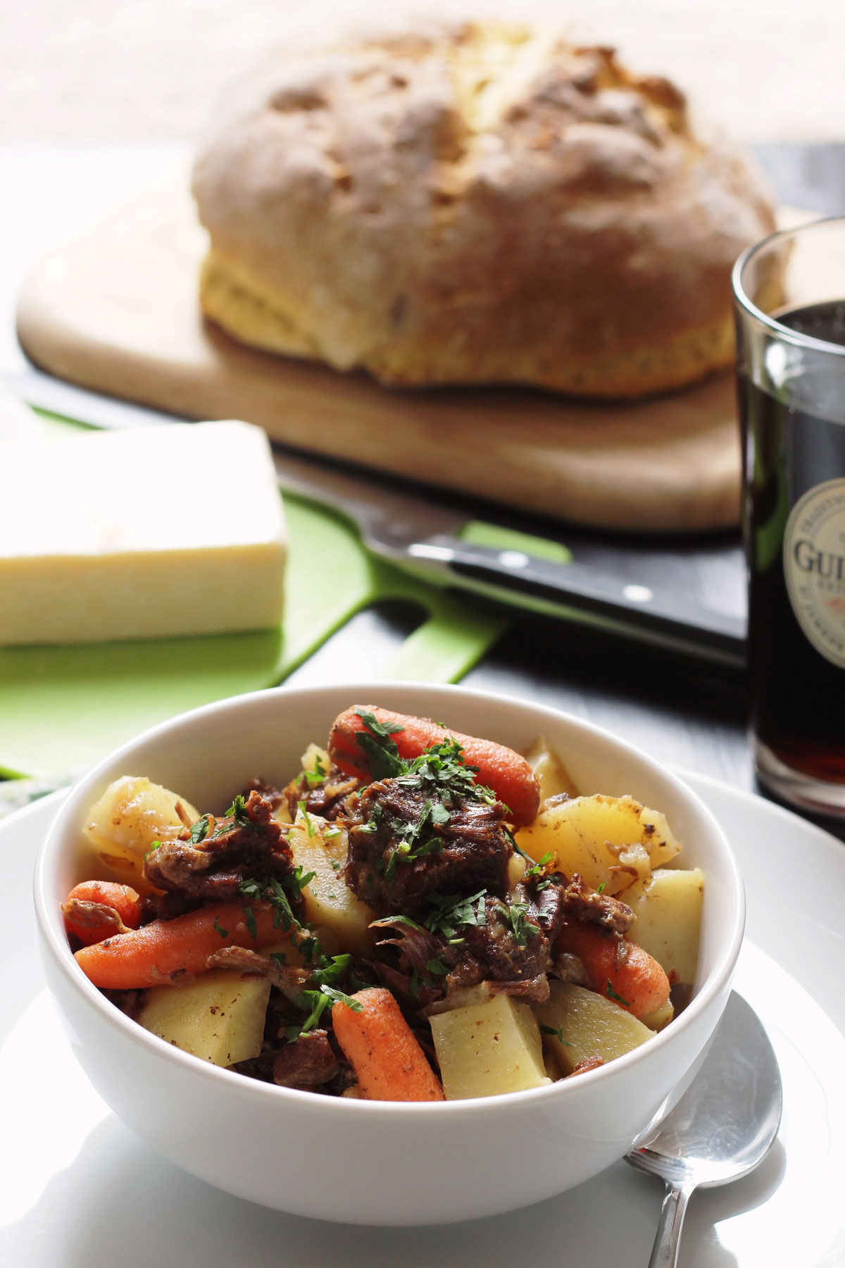 bowl of stew on table with bread cheese and ale