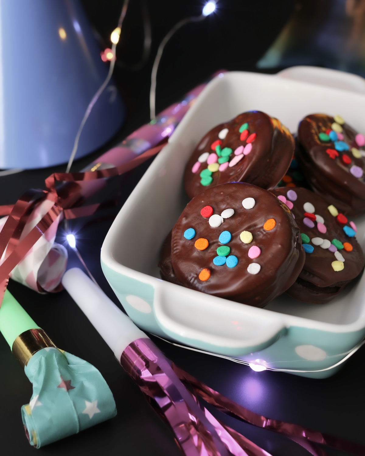new year's themed chocolate dipped oreos in a blue dish.