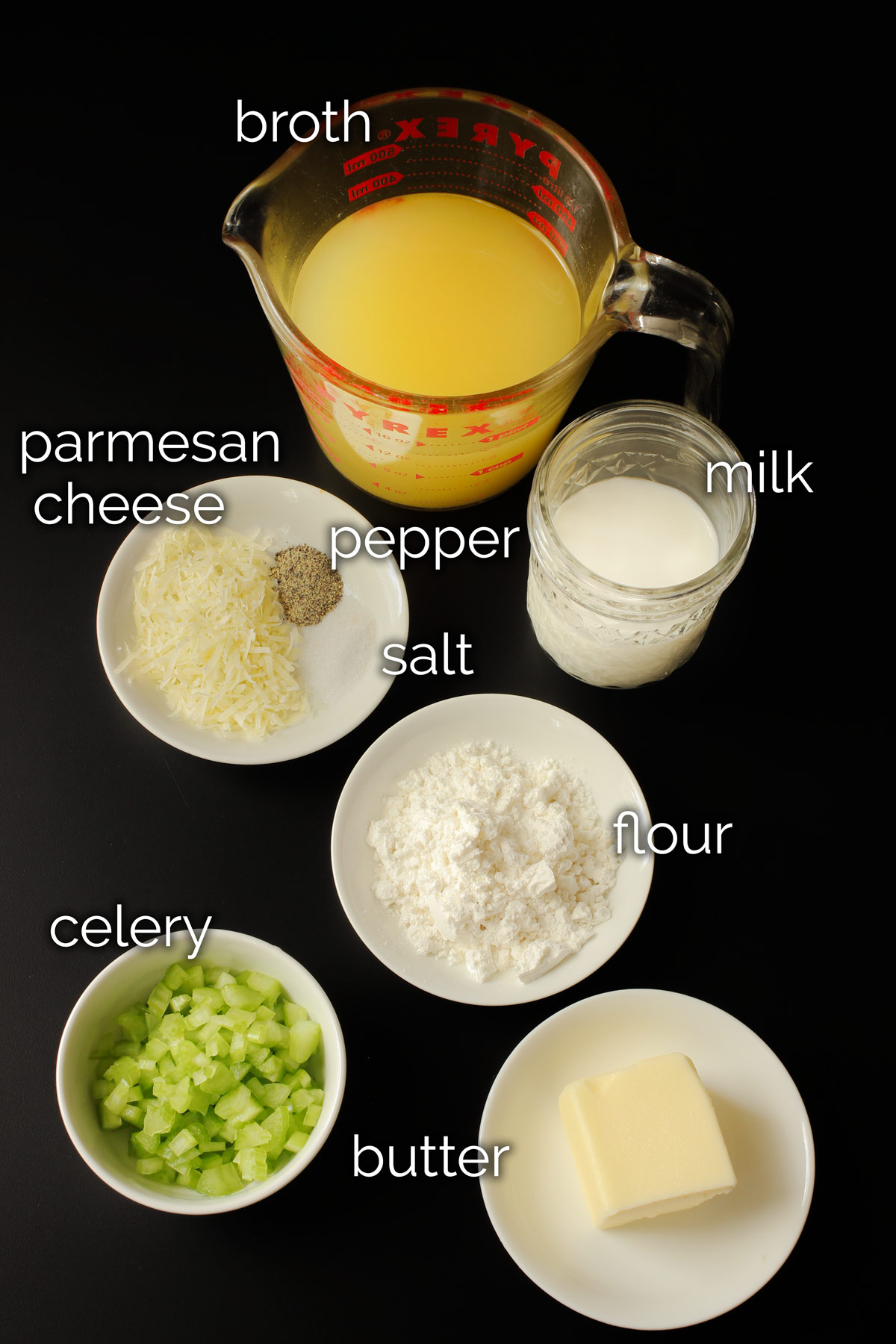 ingredients for cream of celery soup laid out on black table top