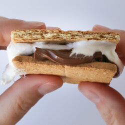 squishing a smore between two hands.