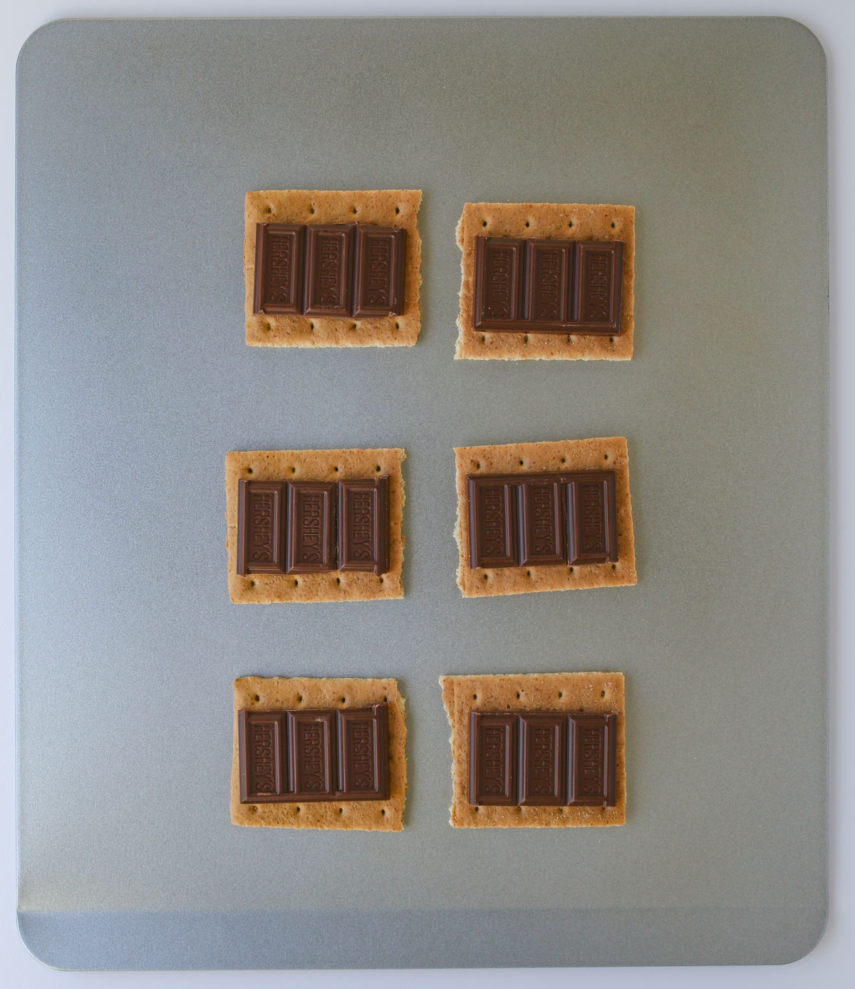 chocolate pieces on the graham crackers on baking sheet.