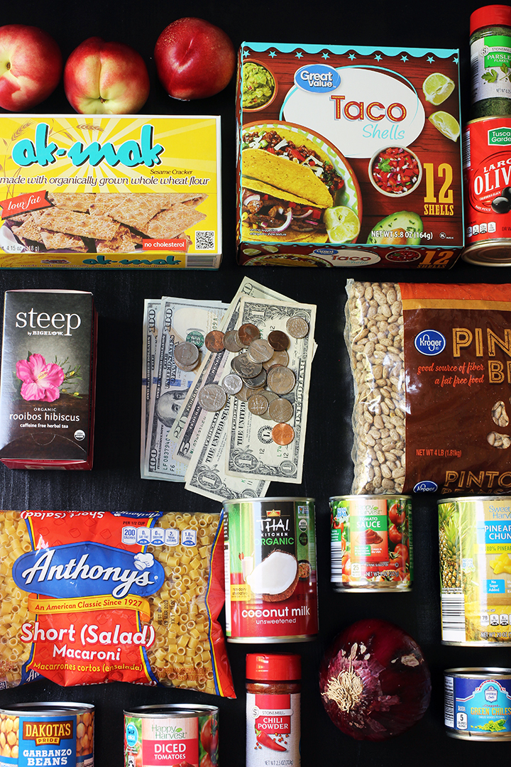 flatlay of groceries and cash on black tabletop