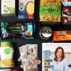 flatlay of groceries cookbook and money with coins and bills