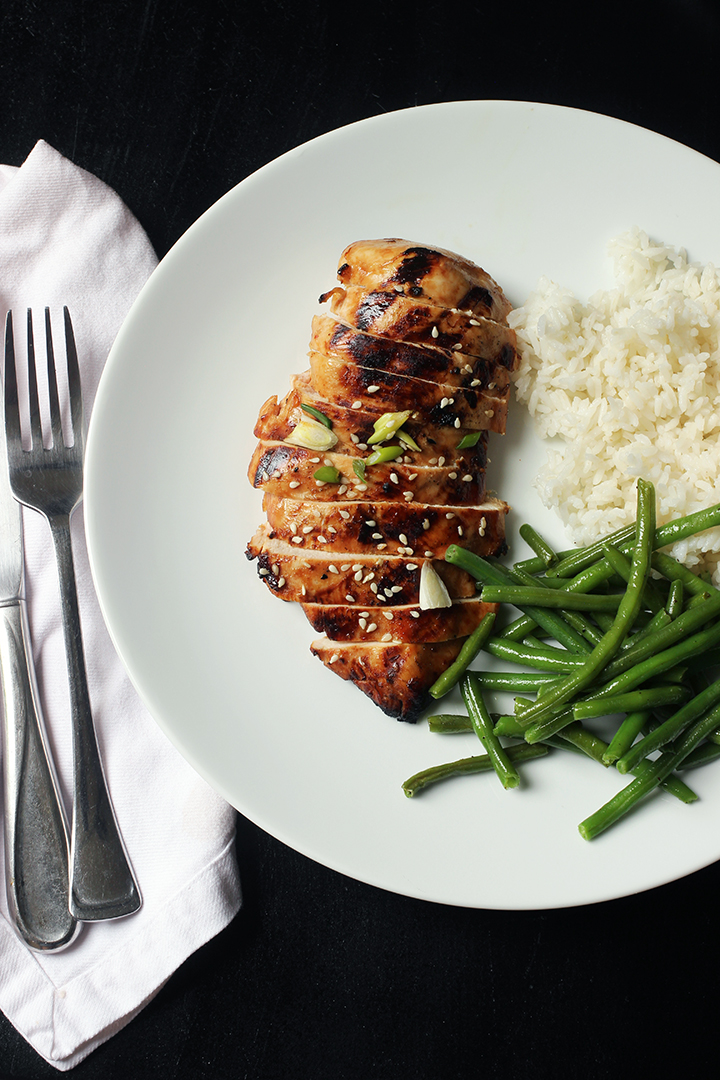 fork and knife next to dinner plate of asian chicken