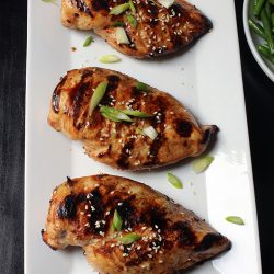 three grilled Asian Chicken breasts on a white tray