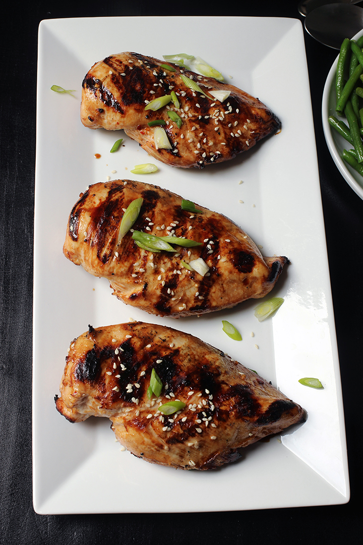 three grilled Asian Chicken breasts on a white tray