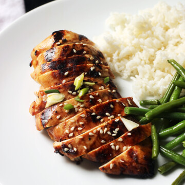 white dinner plate with asian chicken rice and green beans