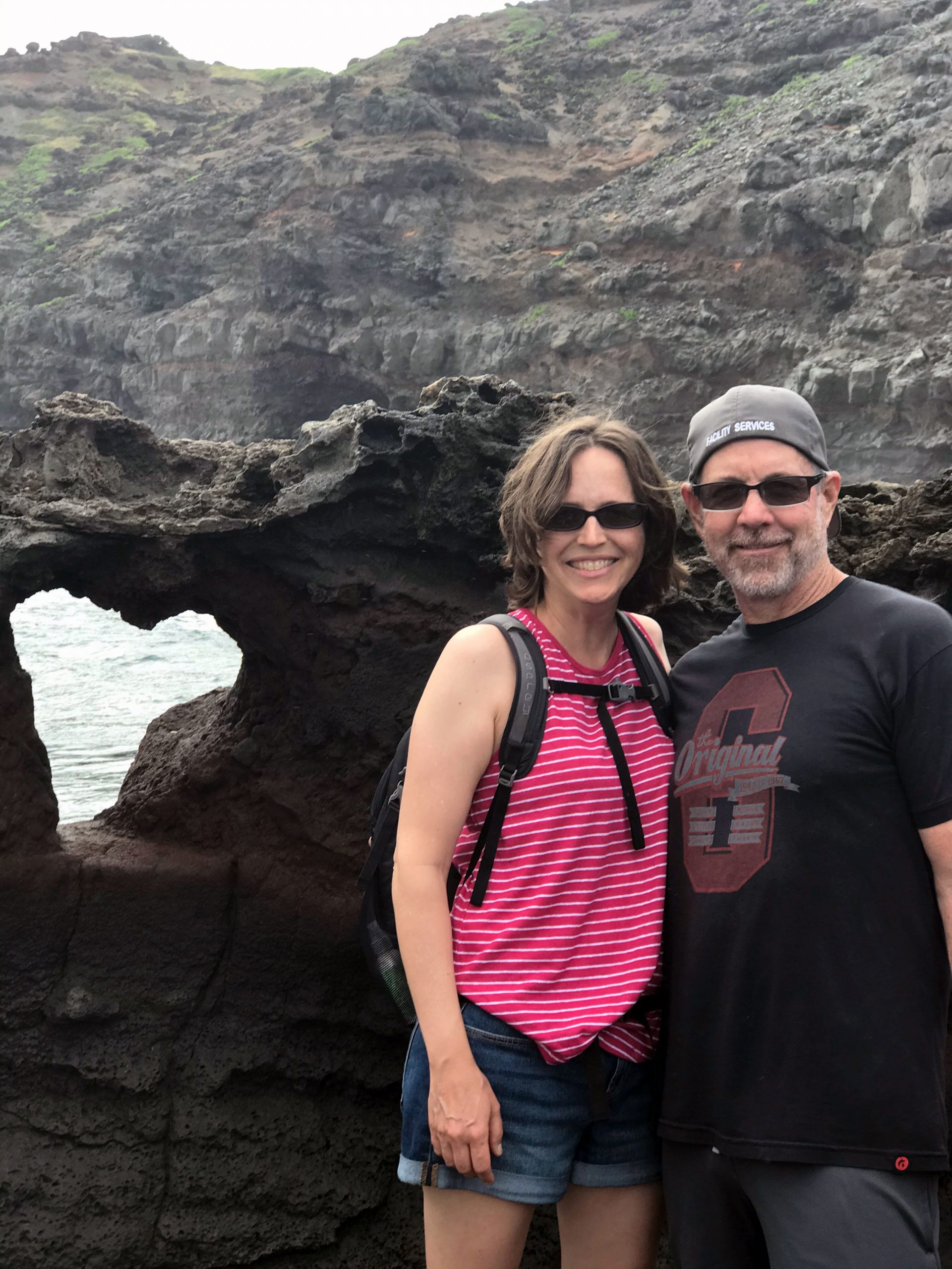 Jessica and Bryan Fisher standing in front of heart-shaped rock in Maui