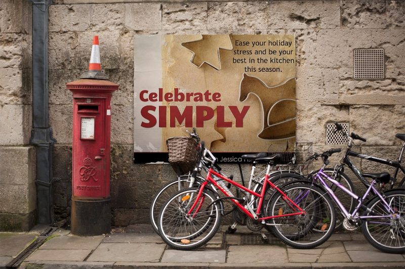 bicycle on city street next to poster of celebrate simply