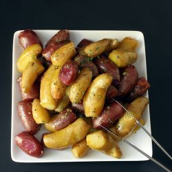 garlic potatoes on square white plate on black table