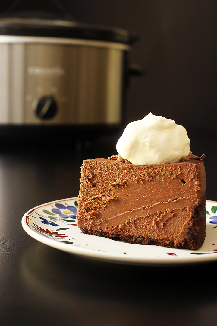 slice of cheesecake on plate near slow cooker