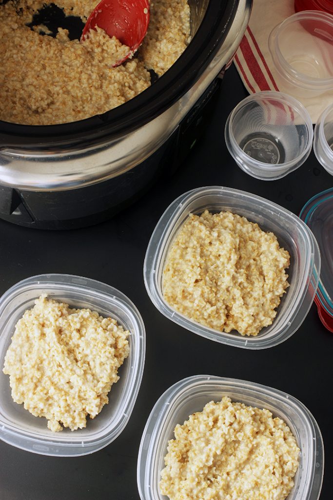 slow cooker of steel cut oats with open meal prep containers