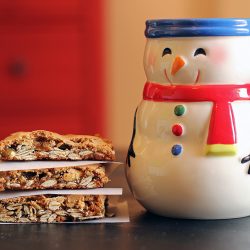 stack of cookie bars next to snowman mug