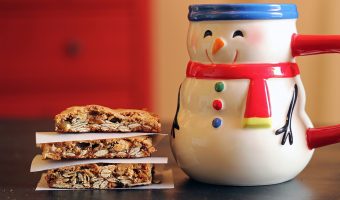 stack of cookie bars next to snowman mug