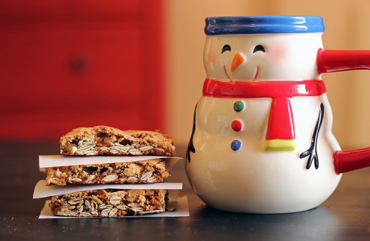 stack of cookie bars next to snowman mug