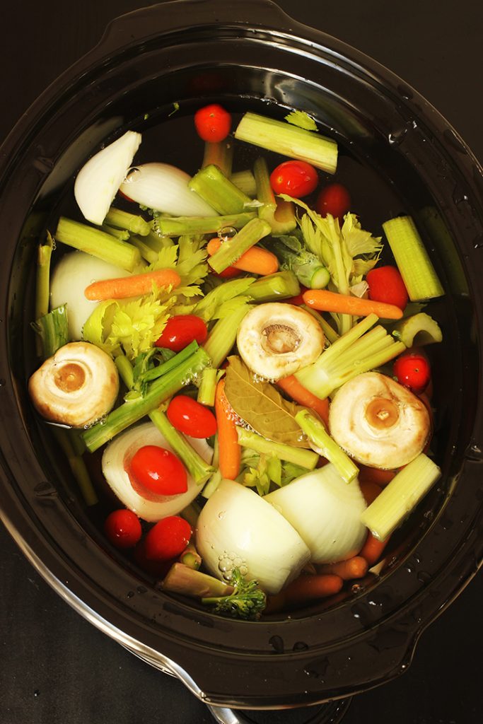 vegetables floating in water in slow cooker