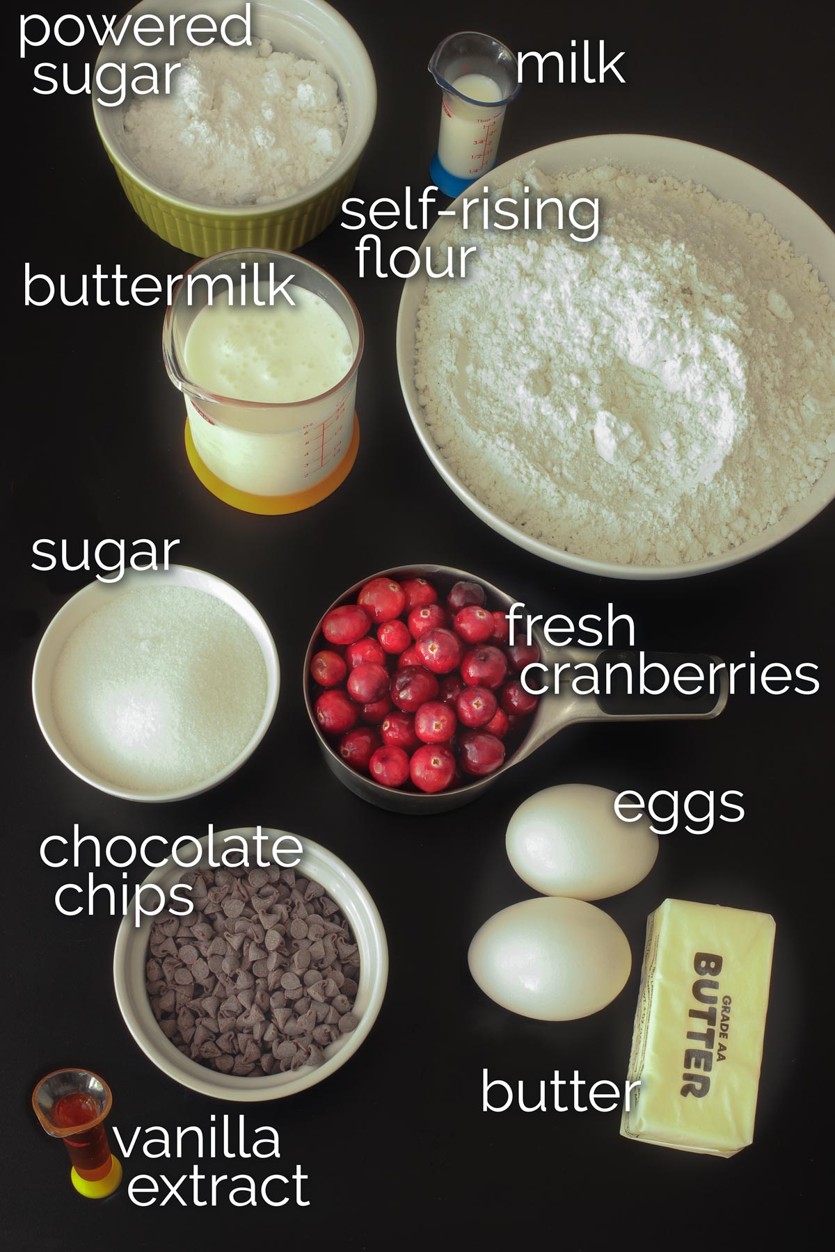 ingredients for cranberry chocolate chip scones laid out on a black table.