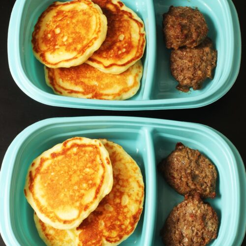 two blue meal prep boxes with pancakes and sausage patties.