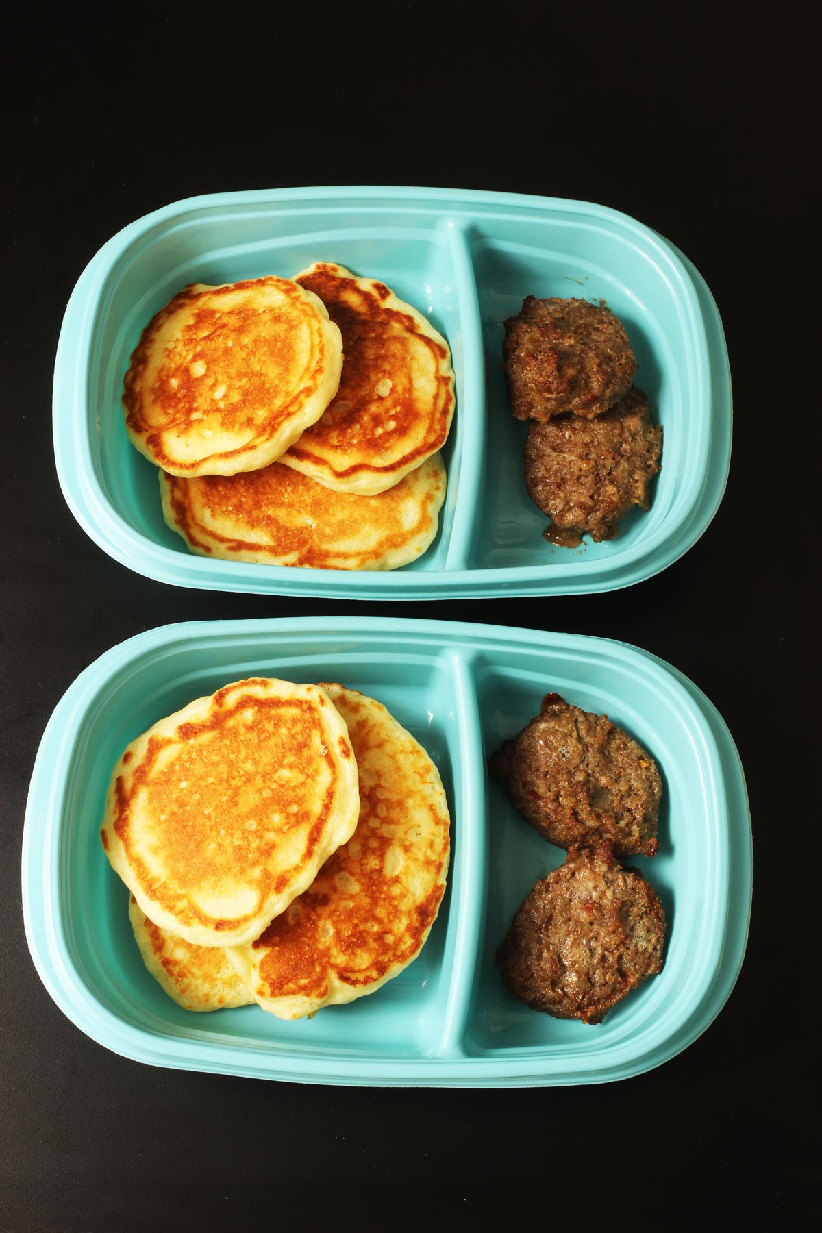 pancakes and sausages in meal prep boxes.