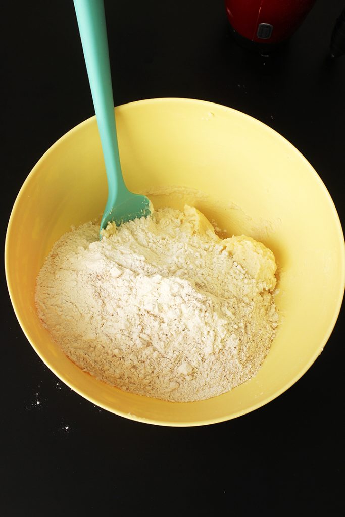 adding flour mixture to butter mixture for sugar cookies