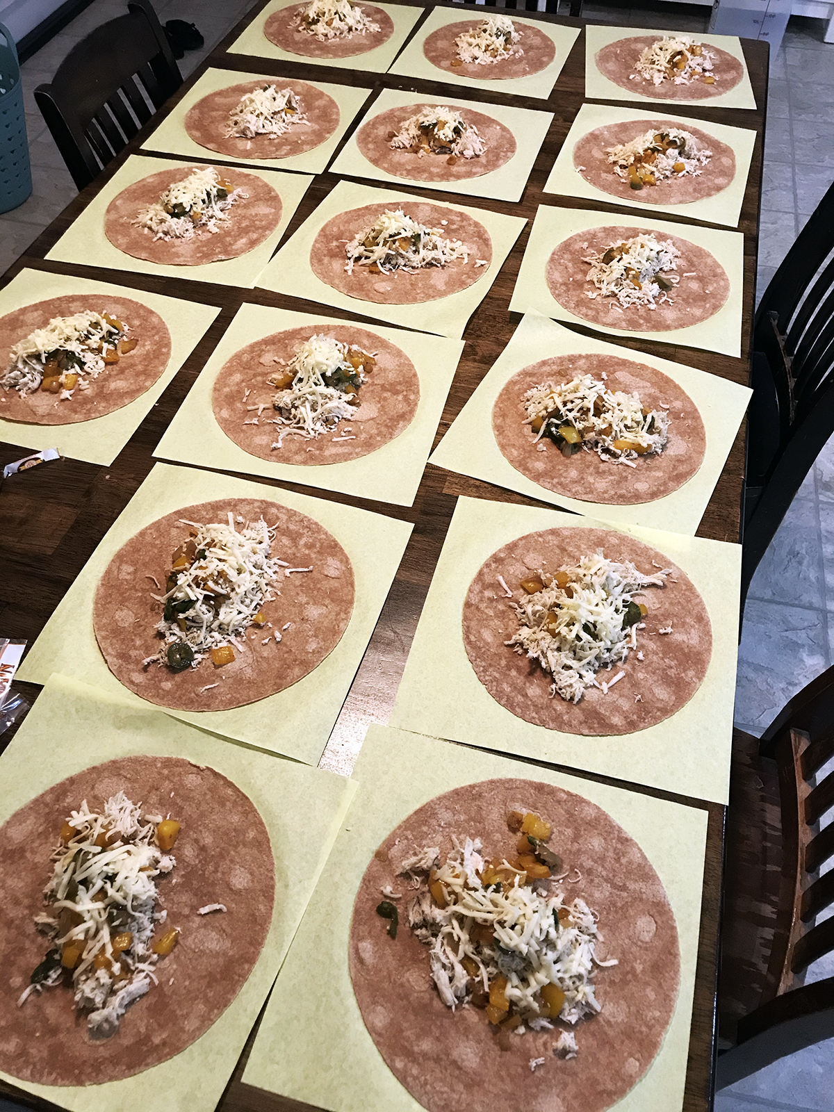 burritos assembled in an array on kitchen table