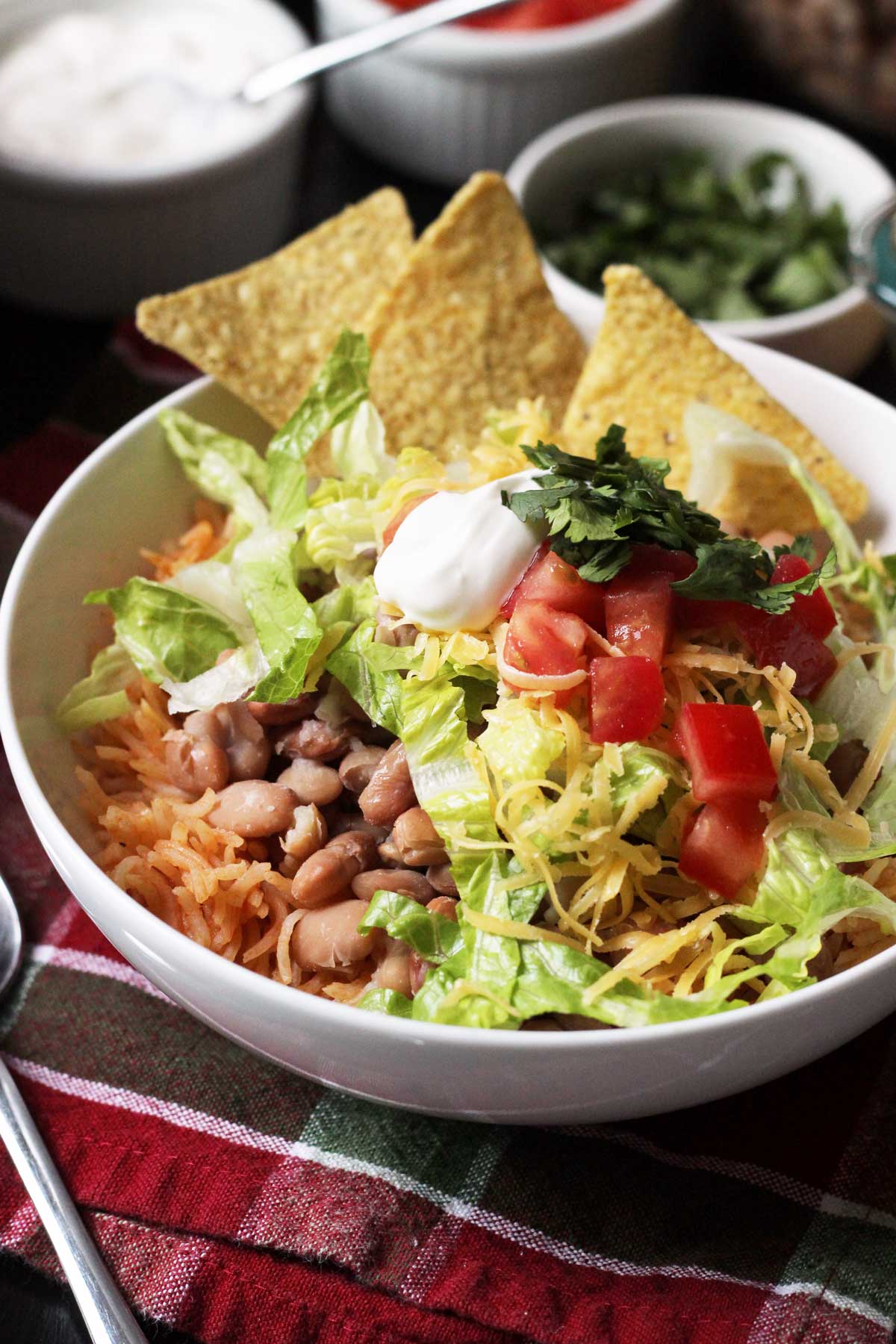 bowl of rice and beans with chips and toppings.