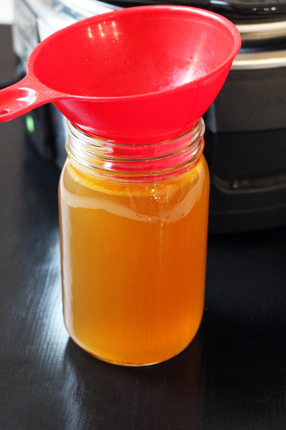 funnel in jar of chicken stock