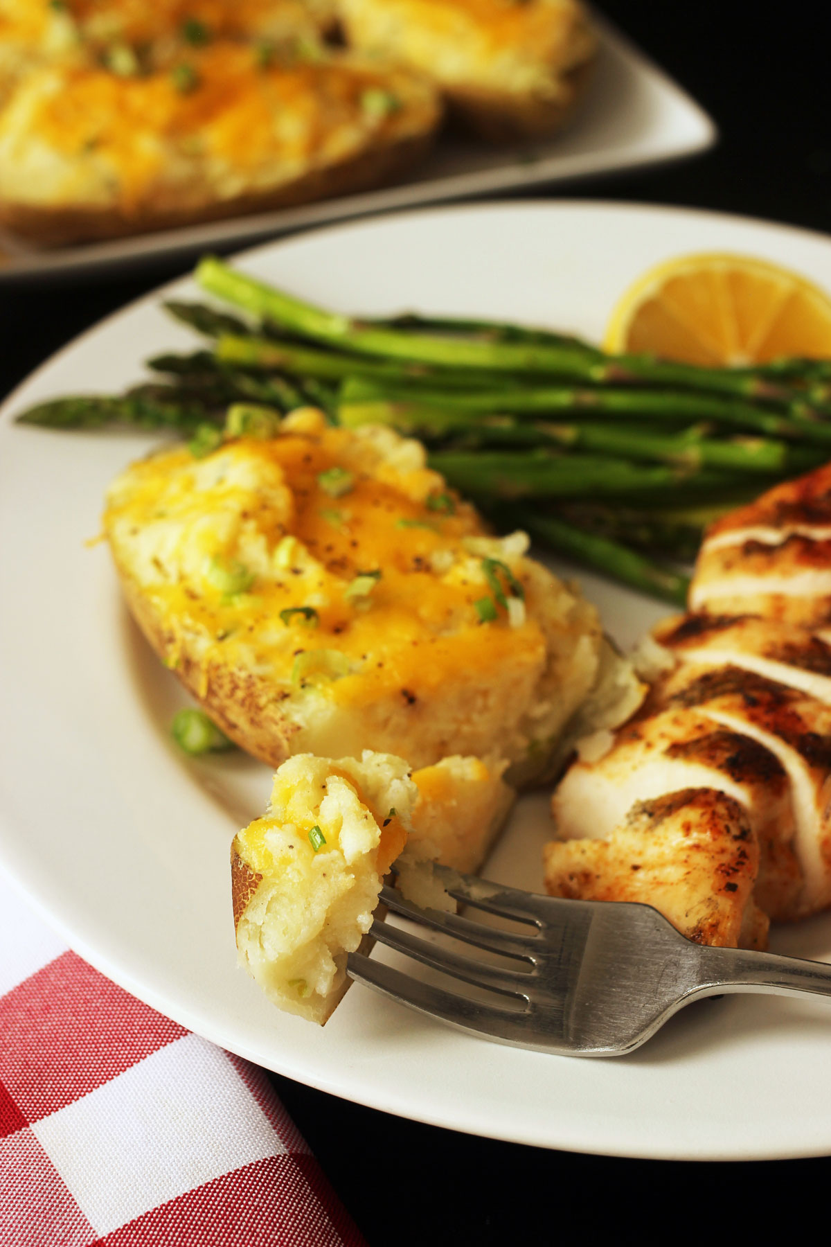 dinner on plate with bite of cheesy stuffed potatoes on fork