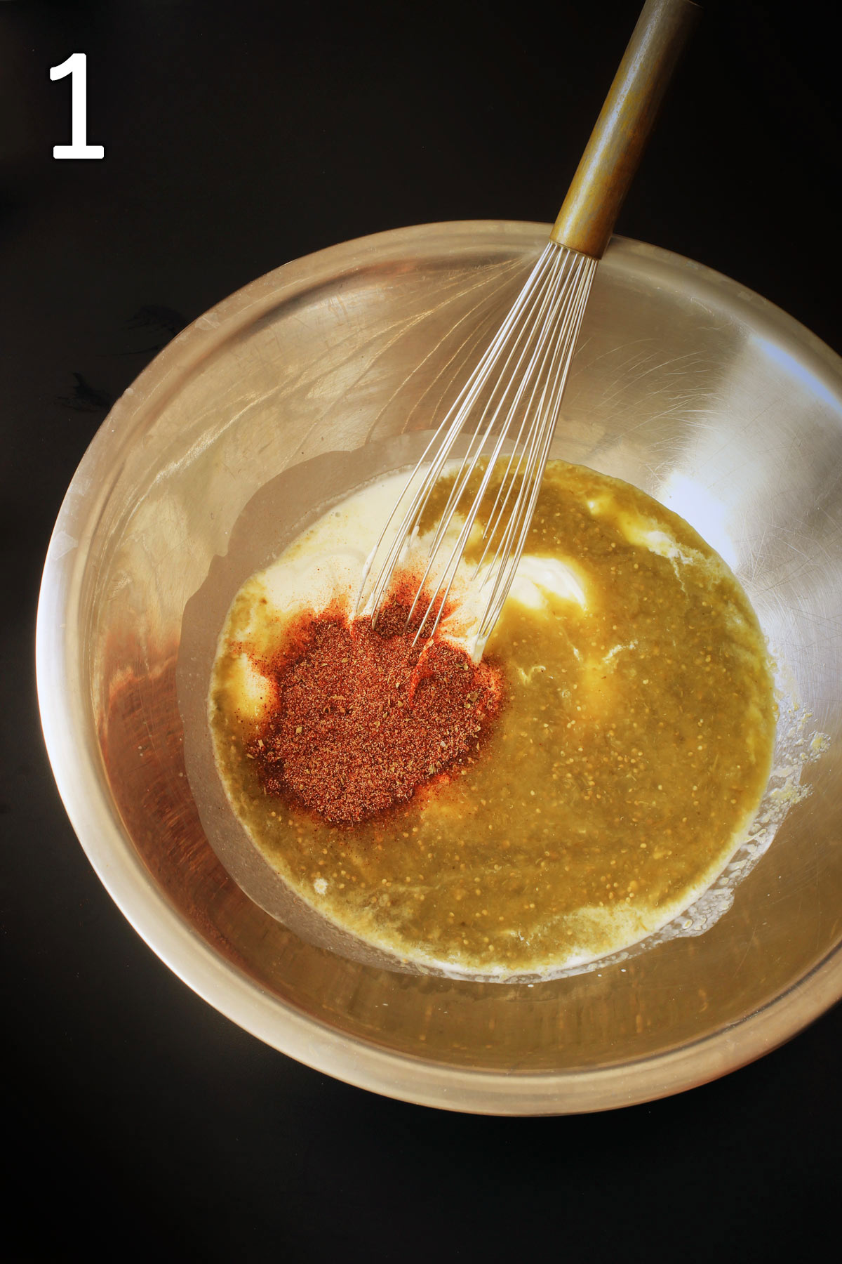 sauce ingredients in a large metal mixing bowl with a whisk.