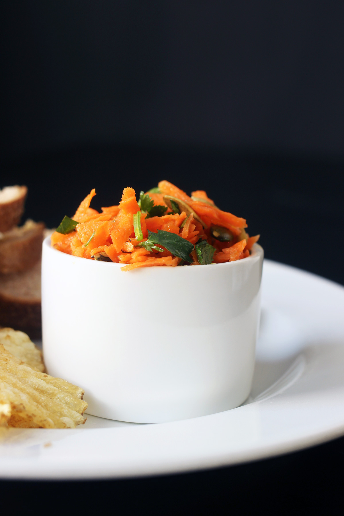 side view of carrot salad in white ramekin