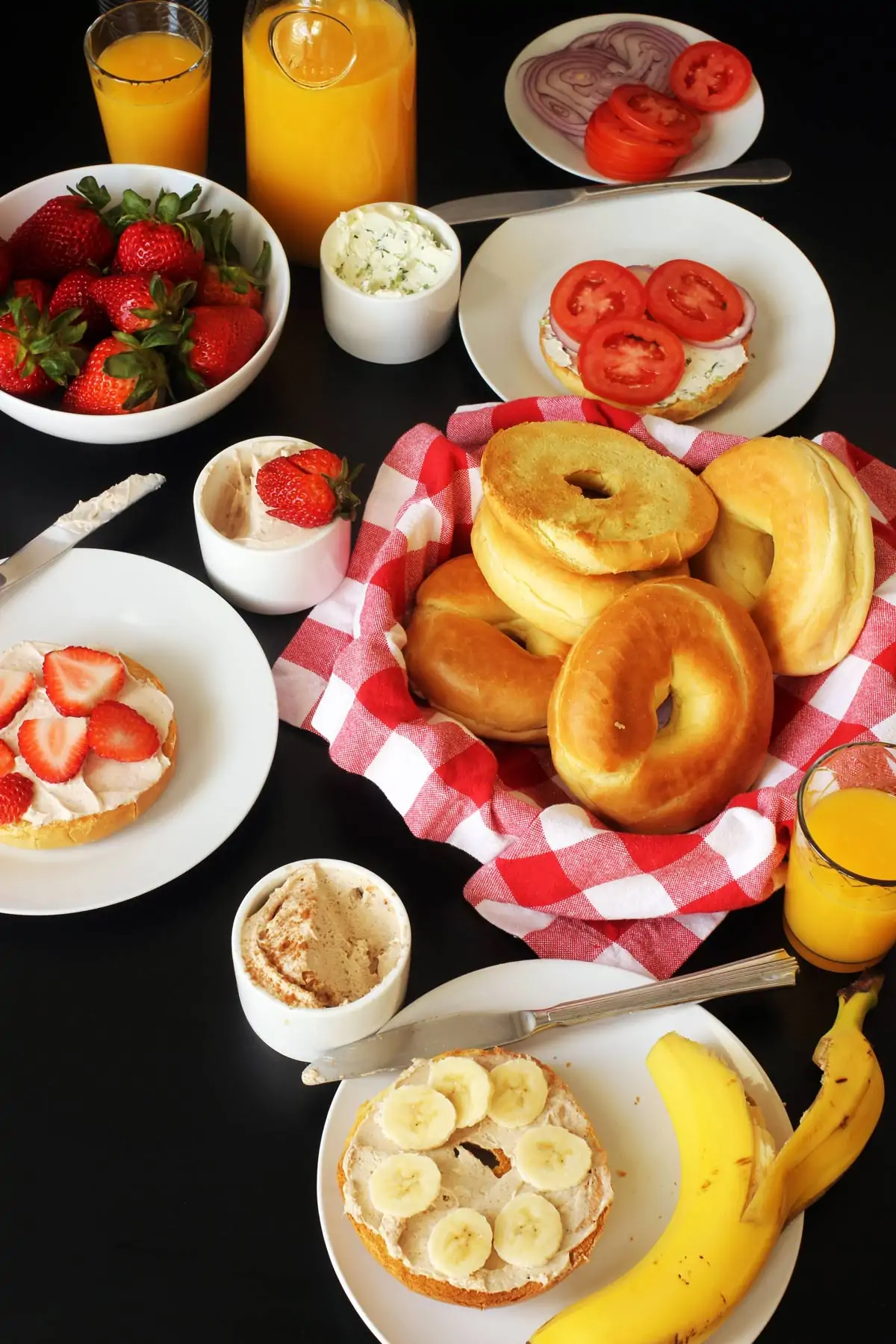 bagel buffet set on table with fruit and juice