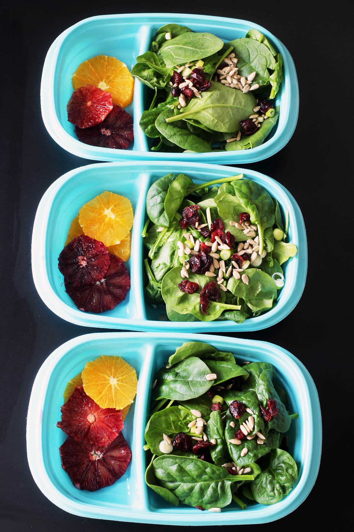 spinach salad in blue meal prep boxes