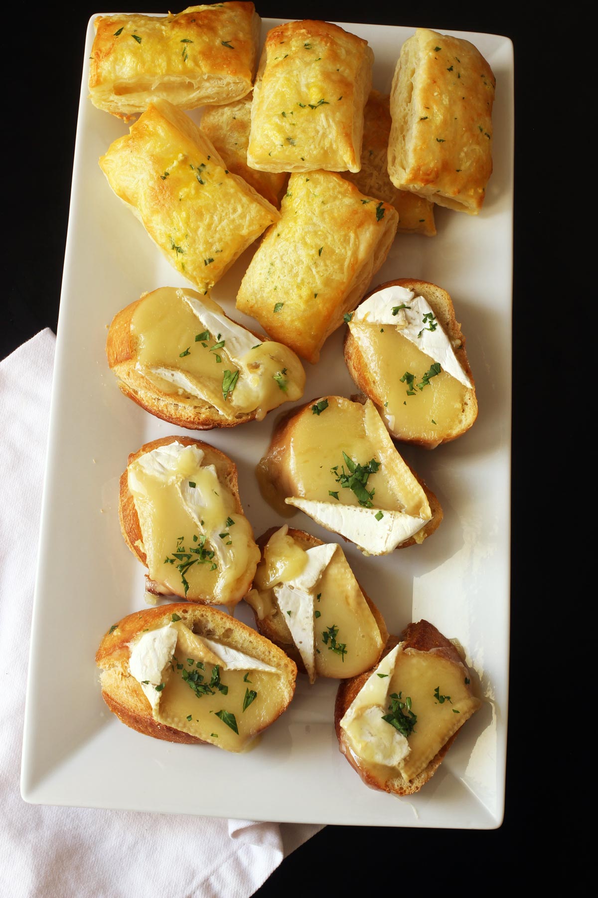 platter of brie toasts and cheese puffs