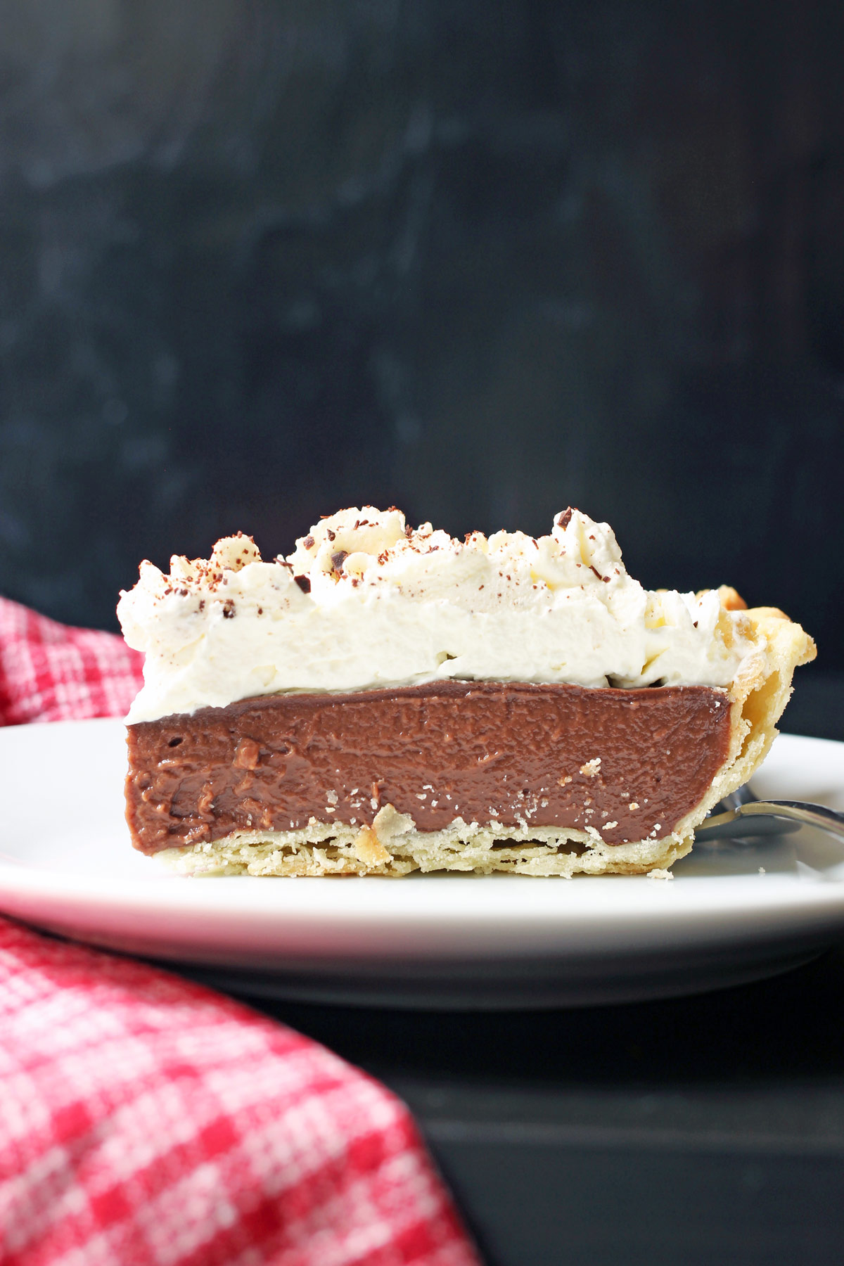 side view of piece of chocolate cream pie on plate