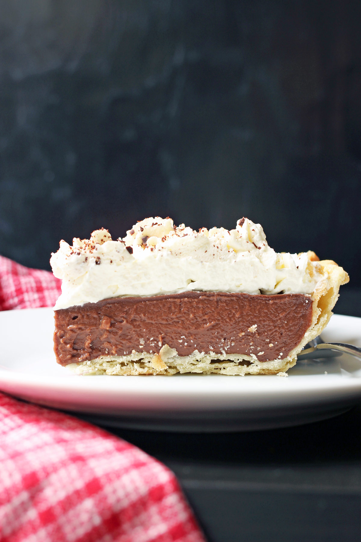 side view of piece of chocolate cream pie on plate.