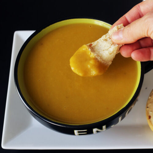 dipping bread in spring vegetable soup