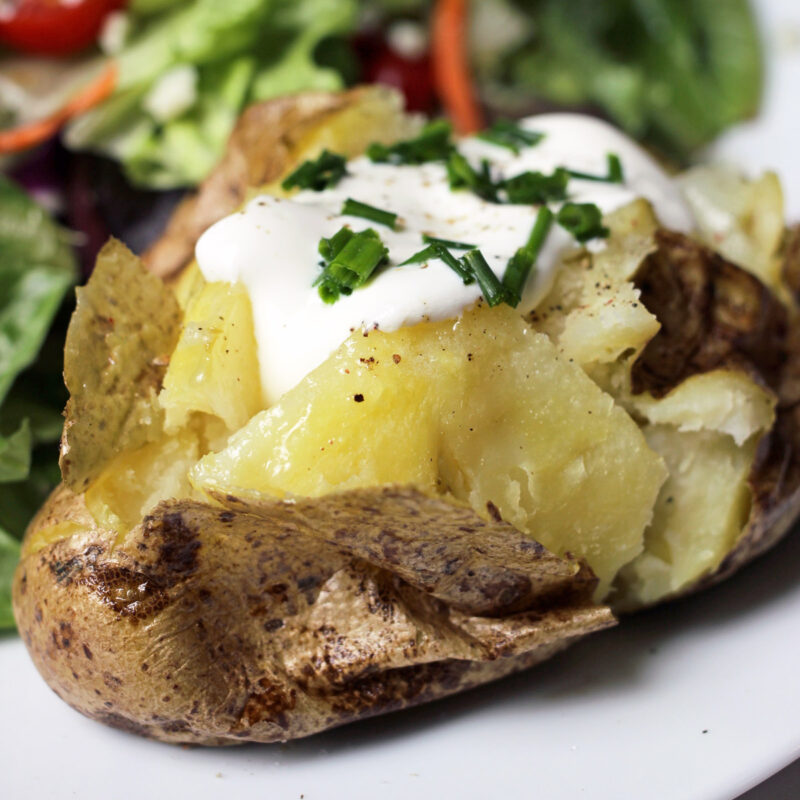 baked potato topped with sour cream and chives