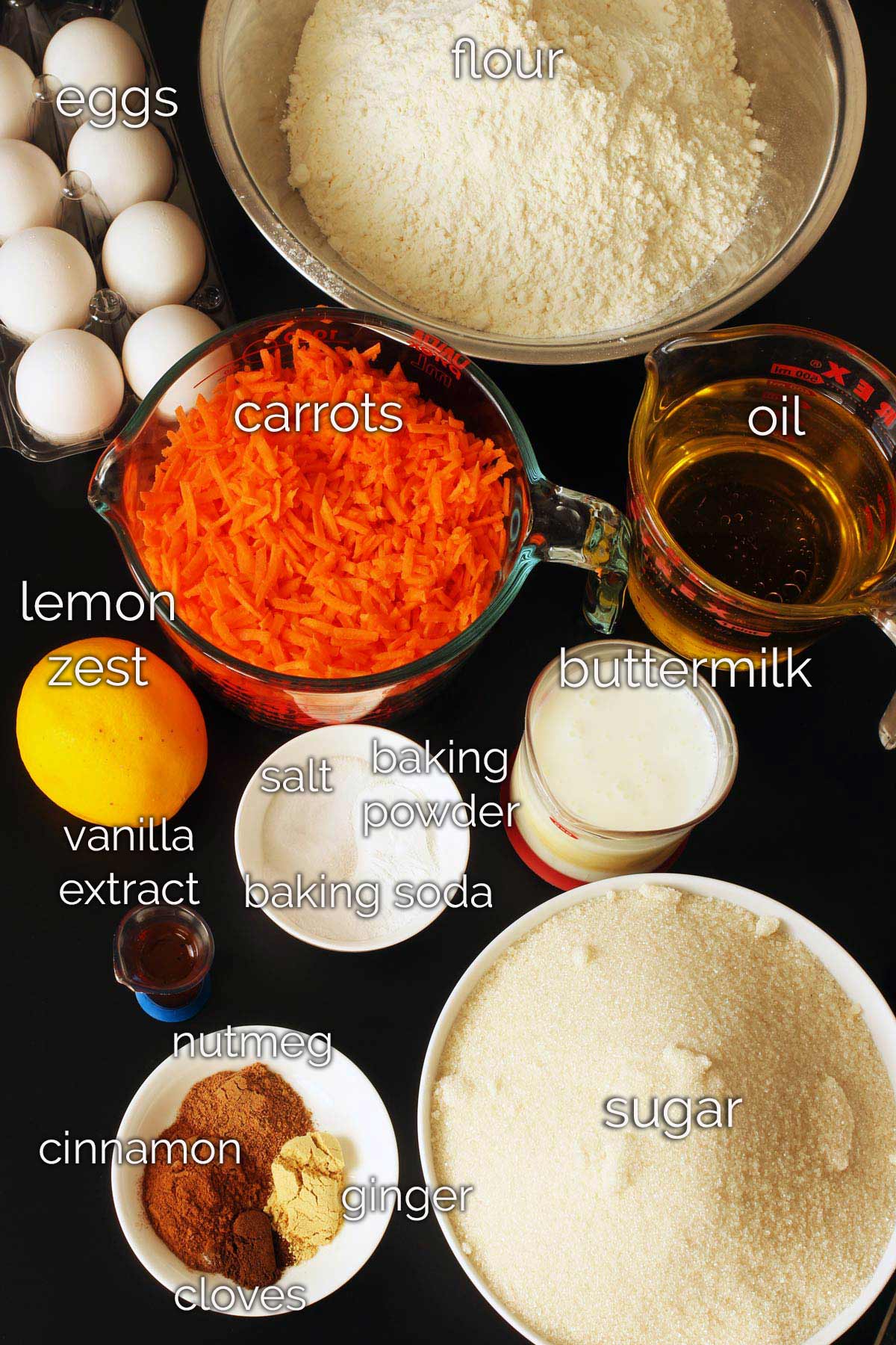 ingredients for carrot bread on black table.