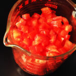 chopped tomatoes in a 2-cup glass measure