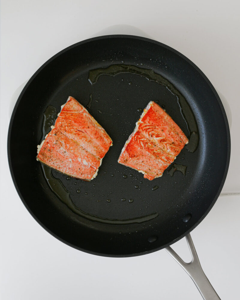 salmon fillets, cooked flesh side up, in the skillet.