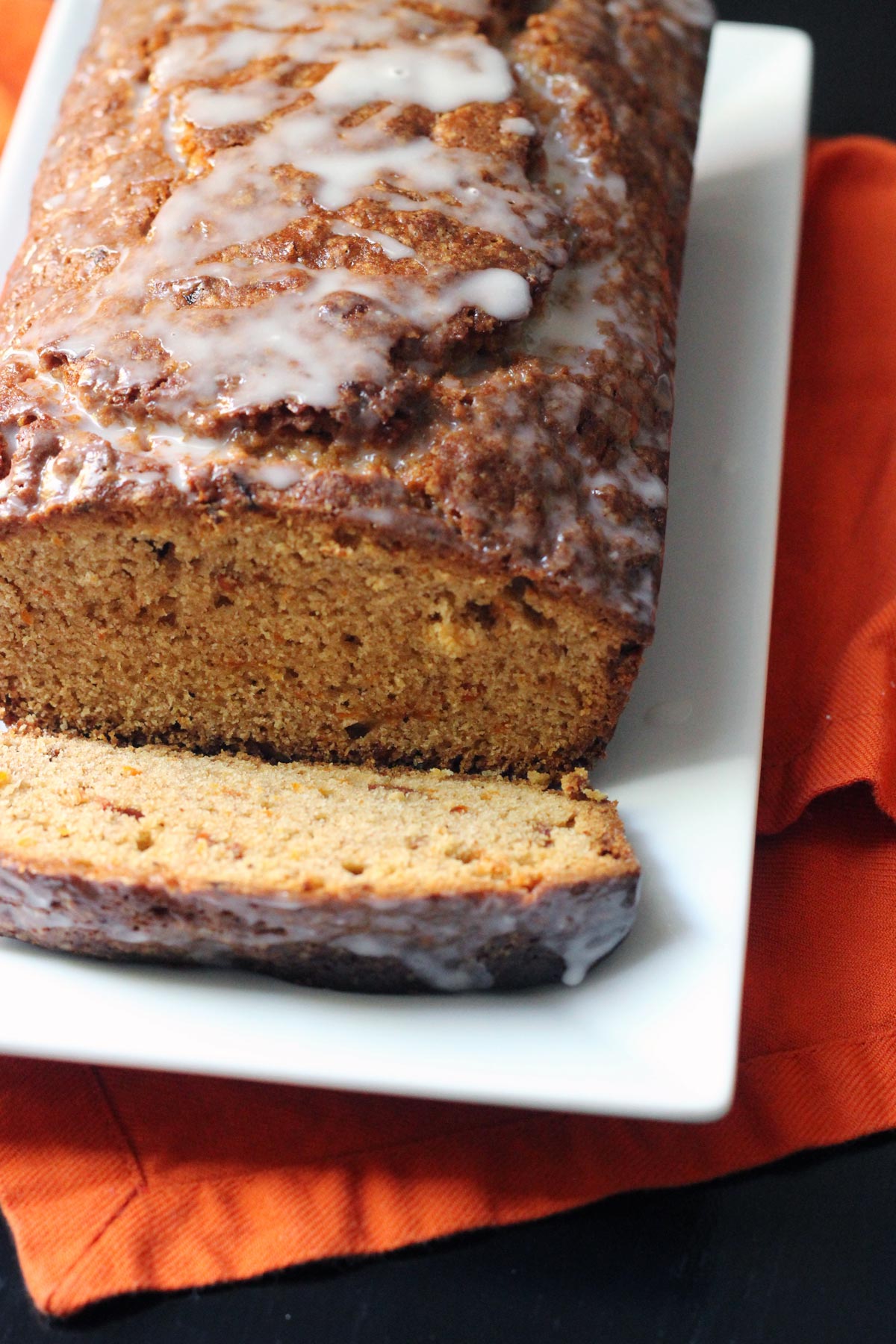 close up of glazed carrot bread on platter