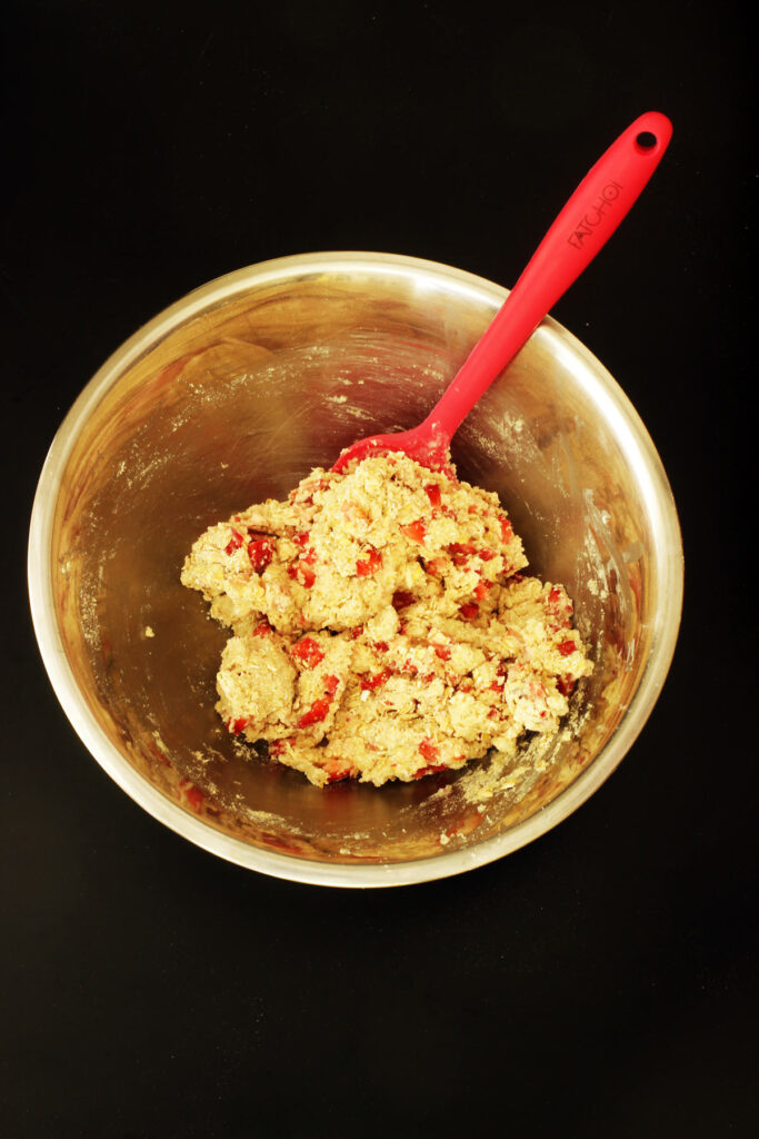 oatcake batter mixed in bowl with red spatula.