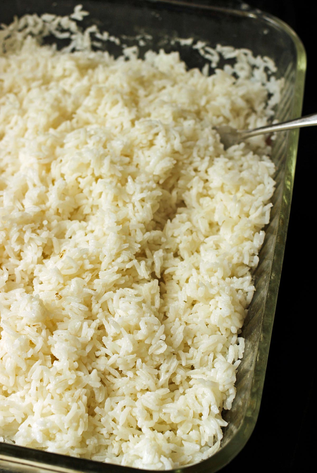 glass baking dish filled with fluffy white rice baked in the oven.