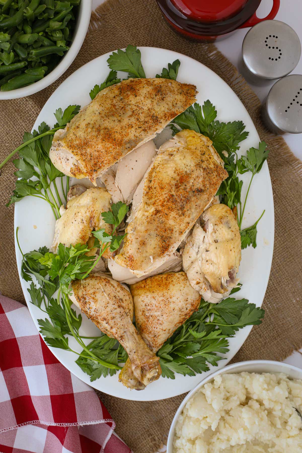 carved whole chicken on platter with parsley.