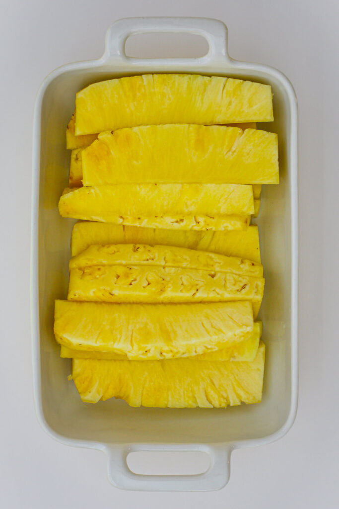 pineapple spears lined up in a dish.