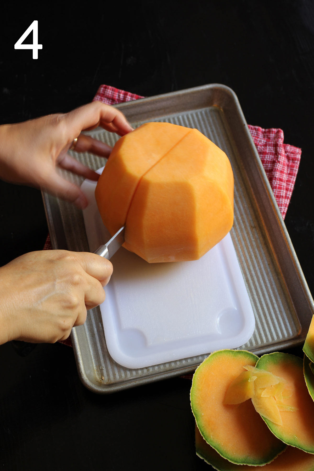 cutting melon in half lengthwise on cutting board within tray.
