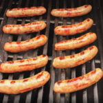 ten grilled brats ready on the grill.