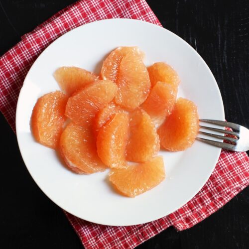 plate of grapefruit sections with fork.