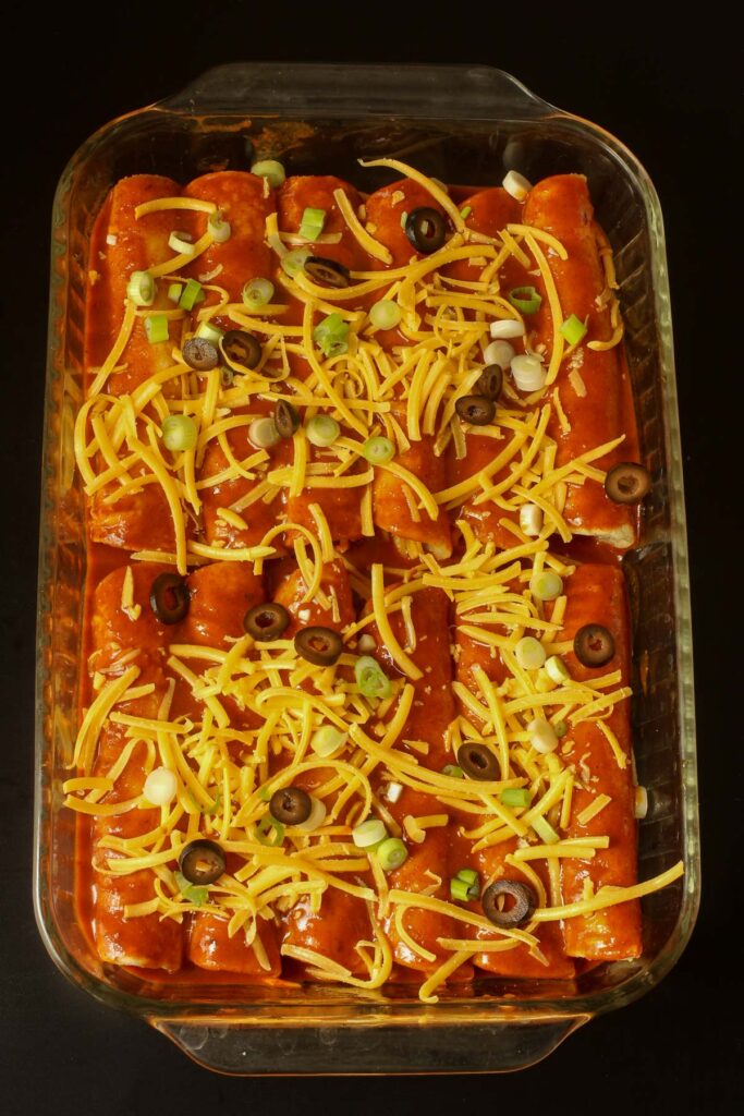 cheese enchiladas assembled in a large glass baking dish.